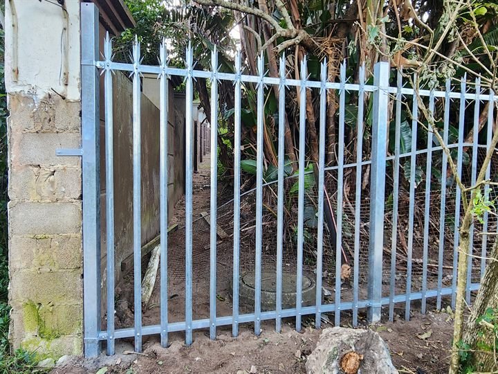 Galvanised steel palisade fence panels along a boundary